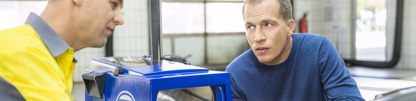 ÖAMTC Techniker erklärt einem Mitglied die Einstellung der Scheinwerfer