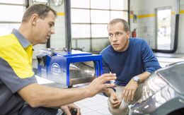 ÖAMTC Techniker erklärt einem Mitglied die Einstellung der Scheinwerfer