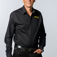 "Porträt eines Mannes mit grauem Haar mit schwarzem Hemd und schwarzer Hose"