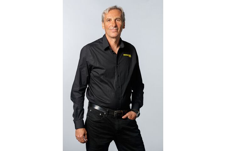 "Porträt eines Mannes mit grauem Haar mit schwarzem Hemd und schwarzer Hose"