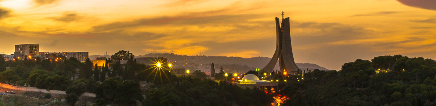Stimmungsvolle Panoramaaufnahme von Algier im Abendlicht mit Blick auf das Märtyrerdenkmal und die Dächer der Stadt