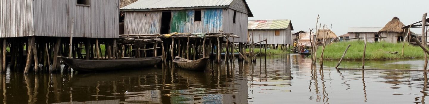 Panoramablick auf Fischerhütten am Ufer des Nokoué-Sees im Süden von Benin, eingebettet in eine ruhige Wasserlandschaft
