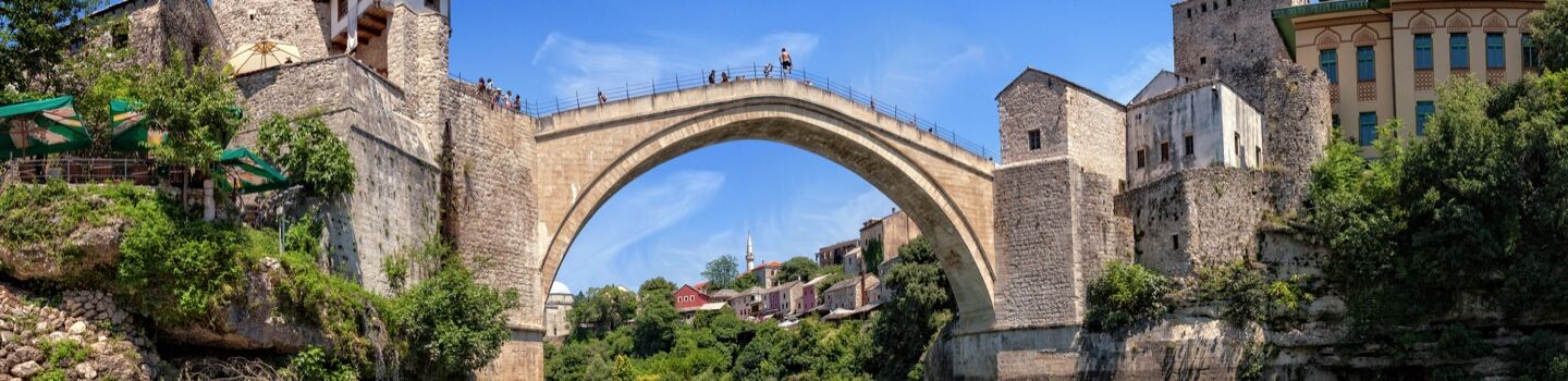Panoramaaufnahme der Alten Brücke (Stari Most) in Mostar, Bosnien und Herzegowina, mit historischem Stadtbild im Hintergrund