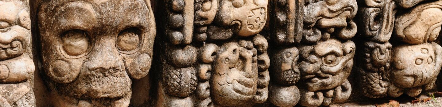 Beeindruckende Maya-Schnitzereien, die faszinierende steinerne Köpfe darstellen, als stille Zeugen einer längst vergangenen Zivilisation.