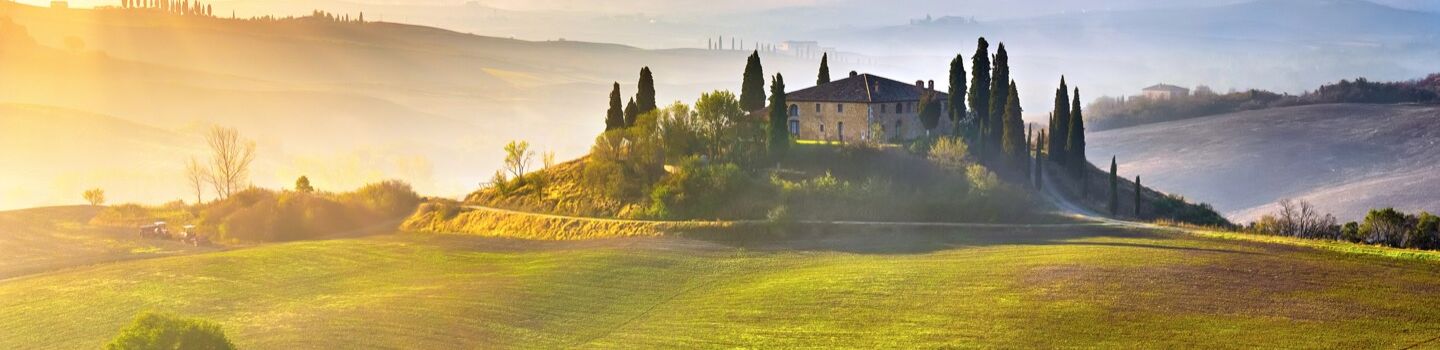 Hügellandschaft in der Toskana mit Haus in der Mitte