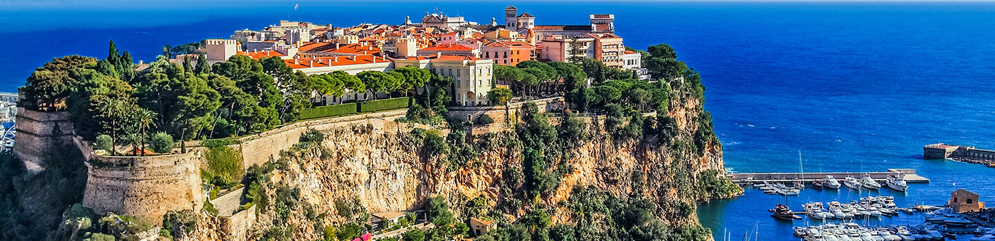 Luftaufnahme des Fürstenpalastes in Monaco mit Blick auf die Felsen und das Mittelmeer im Hintergrund