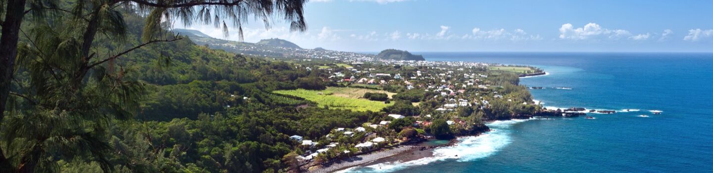 Panoramablick bei Saint-Philippe auf La Réunion mit Lavagestein am Indischen Ozean und dichter Vegetation