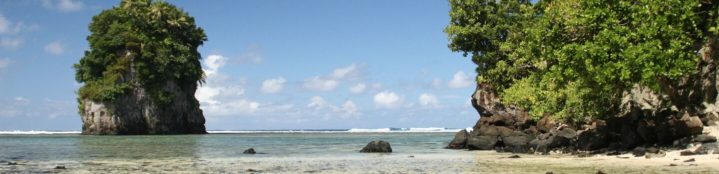 Bild zeigt den wunderschönen Fata Ma Fui Strand in Samoa mit einem markanten Felsen, der aus dem Meer hervorragt.