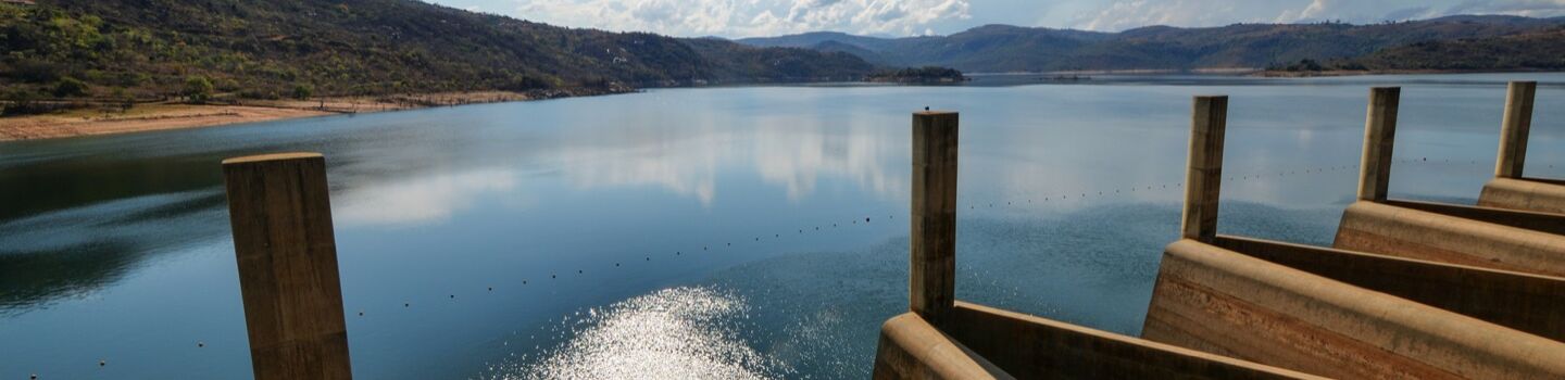 Blick auf den beeindruckenden Maguga-Staudamm in Eswatini, umgeben von einer ruhigen und atemberaubenden Landschaft. 