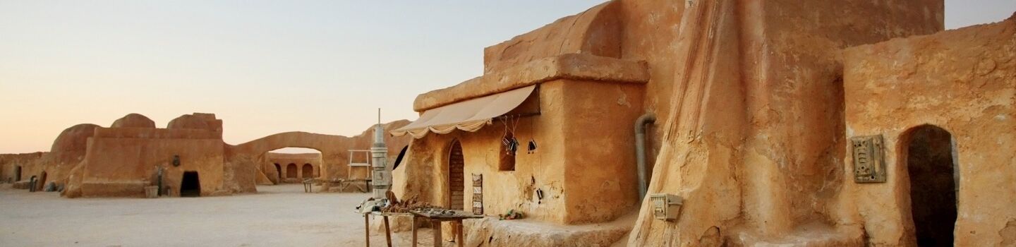 Panoramablick auf Ong Jemel bei Tozeur in Tunesien mit traditionellen Häusern und dem Sahara-Wüstensand im Hintergrund