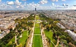 Luftaufnahme des Champ de Mars in Paris mit gepflegten Grünflächen und Wegen, umgeben von der Stadtlandschaft