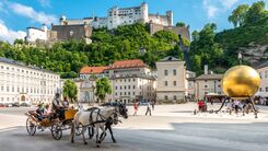 Fiaker in der Salzburger Altstadt. Im Hintergrund ist die Festung Hohensalzburg zu sehen.