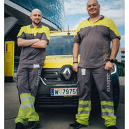 Die beiden Pannenfahrer posieren vor einem Pannenfahrzeug