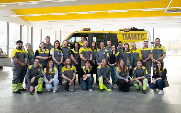 Die Kolleginnen und Kollegen vom Stützpunkt Urfahr stehen vor einem Pannenfahrzeug für ein Teamfoto.