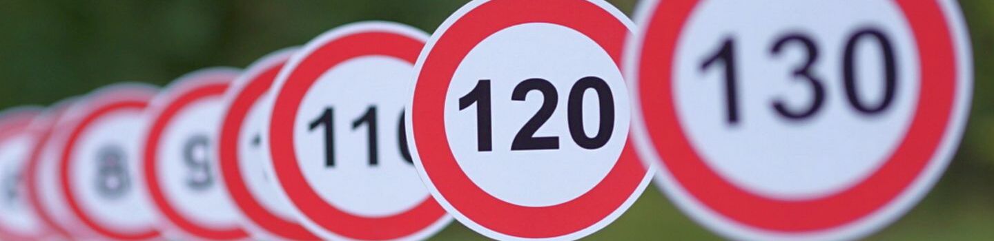 Aufgereihte Verkehrsschilder mit 130, 120 und 110 zulässige Höchstgeschwindigkeit, im Hintergrund verschwimmen die weiteren Schilder und sind unscharf.