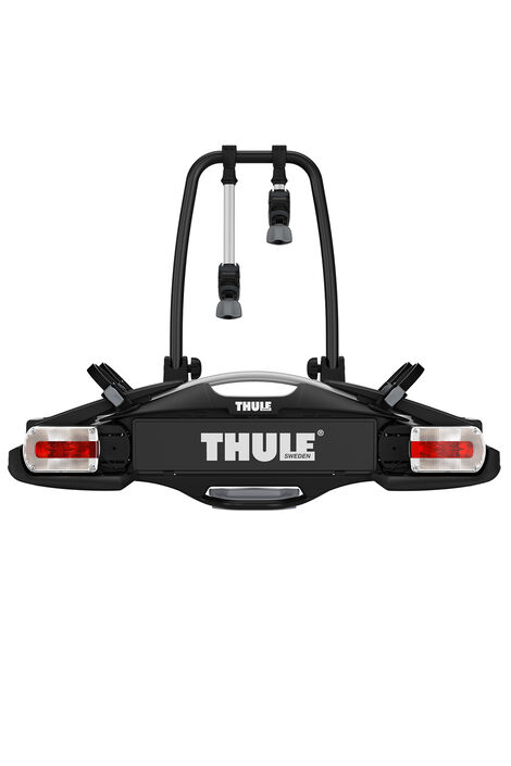 Frontalansicht von schwarzem Fahrradträger mit weißer Aufschrift Thule und roten Rücklichtern.
