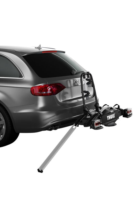Auto auf dem ein Fahrradträger montiert ist. Zum Hinaufbringen der Fahrräder steht eine Rampe angelehnt, dessen Rille dafür sorgt, dass das Rad auf Spur bleibt.