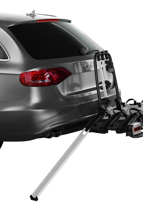 Auto auf dem ein Fahrradträger montiert ist. Zum Hinaufbringen der Fahrräder steht eine Rampe angelehnt, dessen Rille dafür sorgt, dass das Rad auf Spur bleibt.