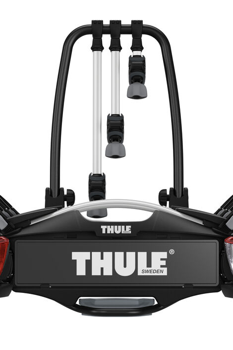 Frontalansicht von schwarzem Fahrradträger mit weißer Aufschrift Thule und roten Rücklichtern.