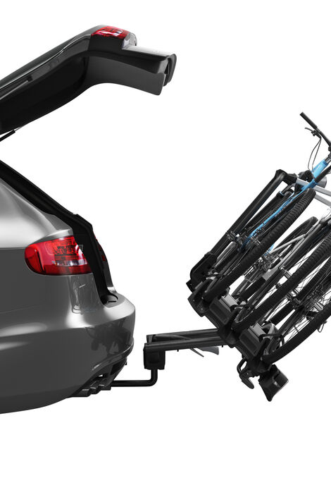 Seitliche Sicht auf ein Auto, dessen Kofferraum geöffnet ist. Auf dem montierten Fahrradträger sind 3 Räder fixiert und der gesamte Träger ist nach hinten gelehnt, damit man ohne Probleme den Kofferraum öffnen und schließen kann.