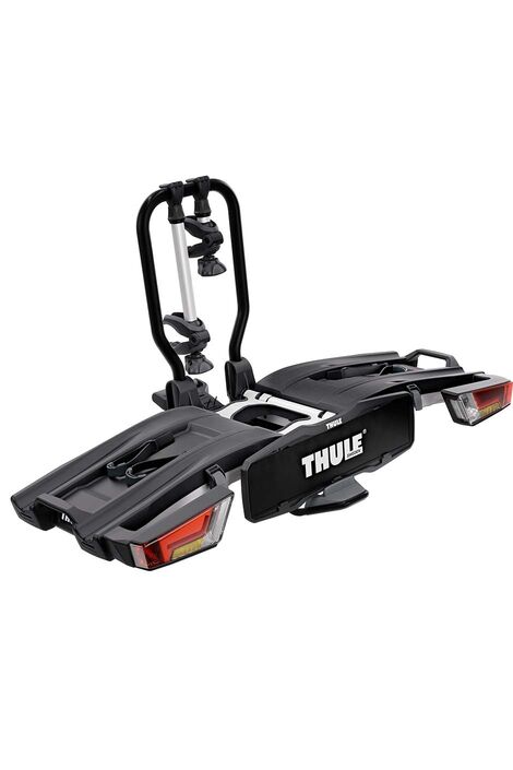 Schwarzer Fahrradträger mit weißer Aufschrift Thule und roten Rücklichter.