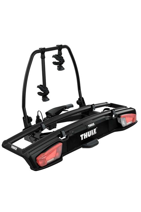 Schwarzer Fahrradträger mit weißer Aufschrift Thule und roten Rücklichter.