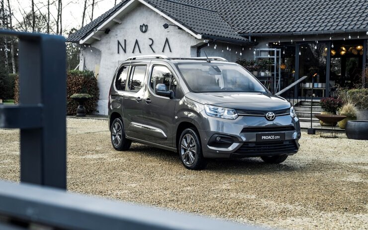 Toyota Proace City.jpg Das Foto zeigt ein stehendes Fahrzeug vor einem Geschäft.