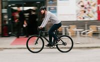 Radfahrer mit Helm fährt auf einem Urban E-Bike.