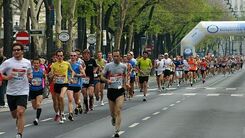 Entlang der Straße laufende Veranstaltungsteilnehmer:innen.