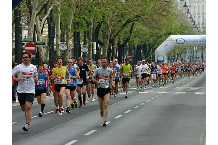 Entlang der Straße laufende Veranstaltungsteilnehmer:innen.