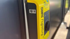 Auf dem Bild sieht man eine sogenannte Wallbox an der E-Fahrzeuge zum Laden angesteckz werden können. Die Wallbox ist gelb und trägt den Schriftzug der ÖAMTC Flugrettung.