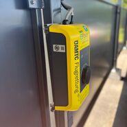 Auf dem Bild sieht man eine sogenannte Wallbox an der E-Fahrzeuge zum Laden angesteckz werden können. Die Wallbox ist gelb und trägt den Schriftzug der ÖAMTC Flugrettung.