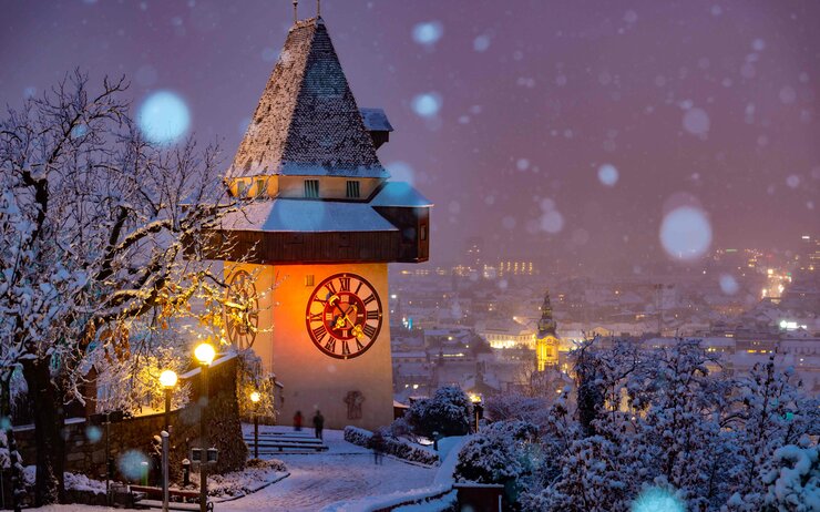 Der Grazer Uhrturm im Winter, festlich beleuchtet im Advent