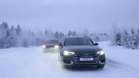 Zwei Autos fahren auf einer Schneefahrbahn. Winterliche und verschneite Bäume und Hintergrund.