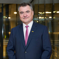 Porträtfoto von ÖAMTC-Präsident Markus Ludvik im Anzug vor einer Glasfassade