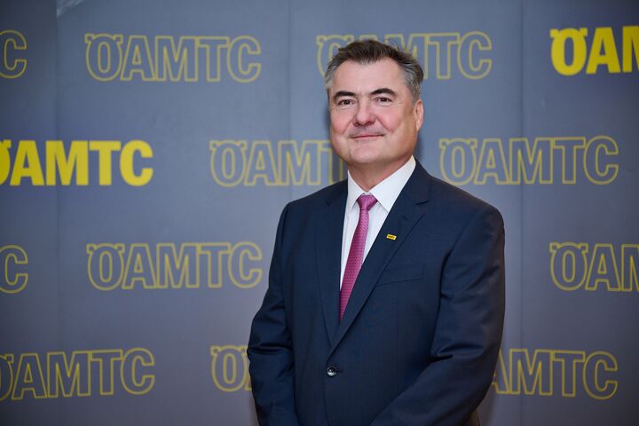Porträtfoto von ÖAMTC-Präsident Markus Ludvik im Anzug vor einer Leinwand mit ÖAMTC-Schriftzügen