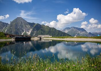 Das Bild zeigt eine Bergkette und davor einen Bergsee. 