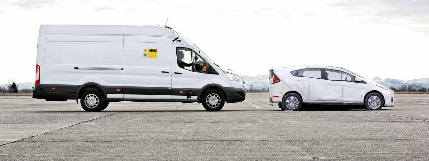 Klein-Lkw steht bzw. bremst hinter Auto auf einer Asphaltstraße.