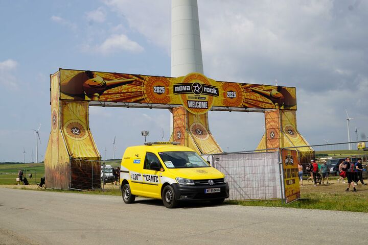 ÖAMTC Pannenfahrer repariert Festivalwagen von Besucher:innen, im Hintergrund ist das Pannenauto zu sehen.