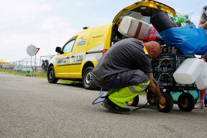 Pannenfahrer repariert einen Festivalwagen, im Hintergrund befindet sich das Pannenauto beim Nova Rock 2025.