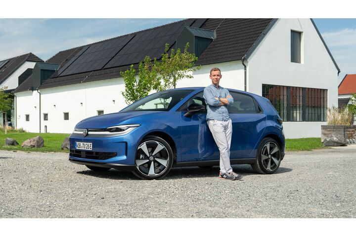 Ein Mann lehnt an einem blauen VW ID Polo.