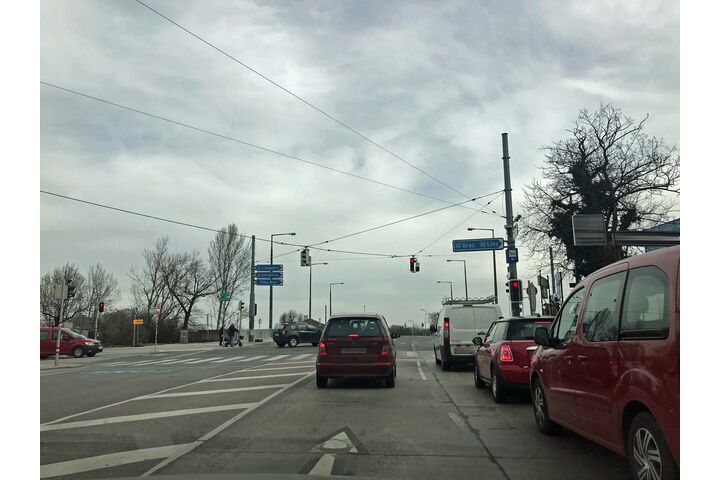 Autos vor einer roten Ampel in einem Baustellenbereich vor einer Brücke