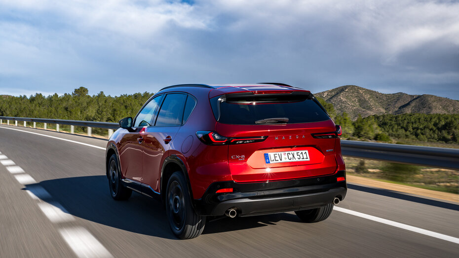 Ein roter Mazda CX-5 fährt auf einer Landstraße, von hinten