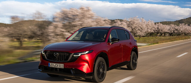 Ein roter Mazda CX-5 fährt auf einer Landstraße