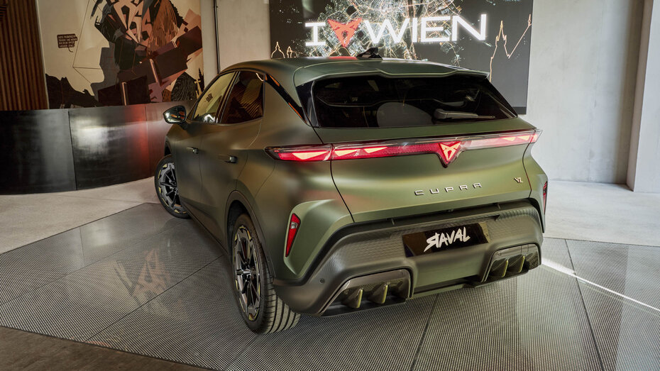 Heck eines grau-grünen Cupra Raval, der in einer großen Fensterauslage steht.