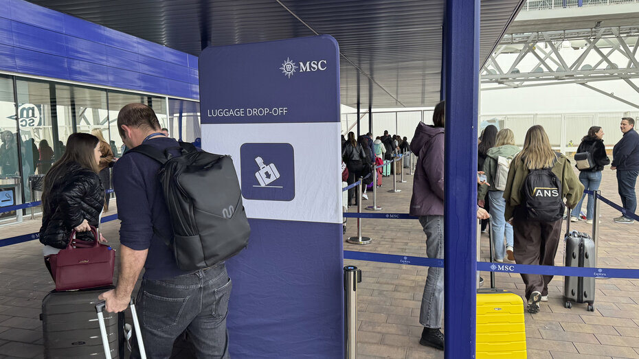 Einschiffung für eine Kreuzfahrt: Menschen stellen sich mit ihrem Koffer an.