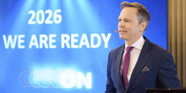 Markus Wildeis, Direktor von Stellantis Austria, steht vor einem blauen Bildschirm.