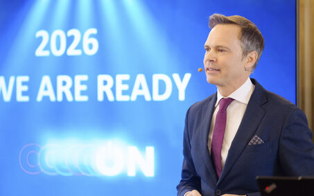 Markus Wildeis, Direktor von Stellantis Austria, steht vor einem blauen Bildschirm.