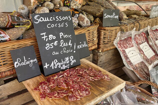 Der Markt und zu kaufen gibt es Salami und harte Wurst und ein teil ist aufgeschnitten.