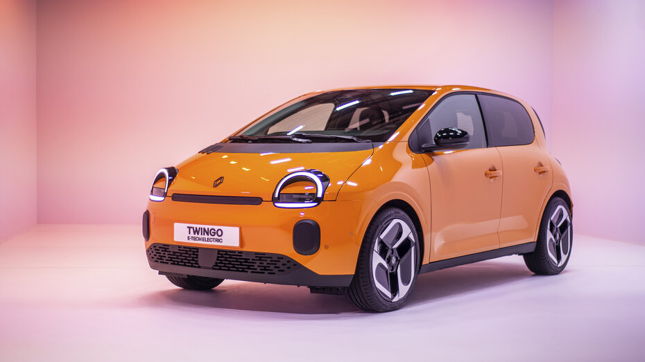 Ein orangener Renault Twingo 2025 steht in einem Studio.